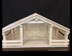 a dog house made out of wooden pallets on a reflective surface with black background