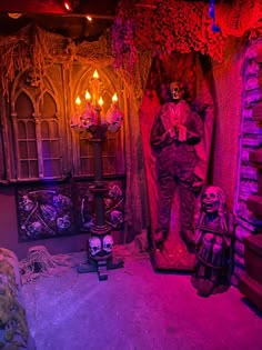 a living room filled with halloween decorations and skulls on the walls, along with candles