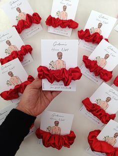 a person holding up some cards with red ruffles on them in front of other cards