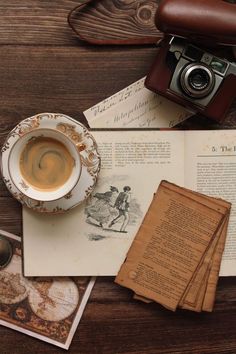 an old book, camera and cup of coffee on a table