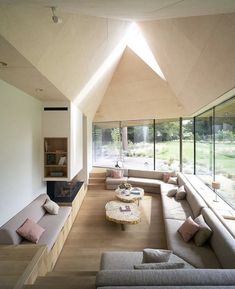 a living room with couches, tables and windows on the side of the wall