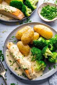 two plates with chicken, potatoes and broccoli covered in gravy on them