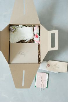 an open box with some items in it on a table next to a card and envelope