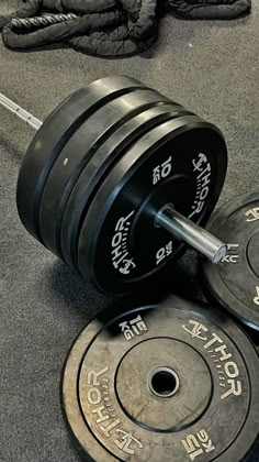 two weight plates and one barbell are on the ground