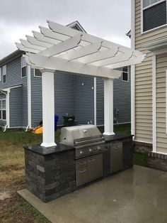 an outdoor kitchen with grill and seating area