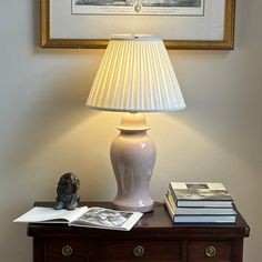 a lamp sitting on top of a table next to a book