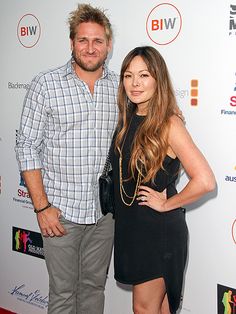 a man standing next to a woman on a red carpet