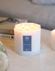 two white candles sitting on top of a table