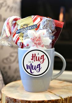 a cup filled with candy and marshmallows sitting on top of a tree stump