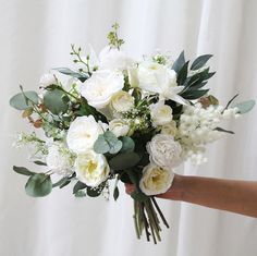 a person holding a bouquet of white flowers