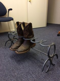 a pair of brown boots sitting on top of a metal sled in an office