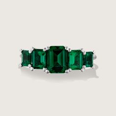 Spectacular. Stunning. Unforgettable. In our new Alexandrina ring we created a goldsmith masterpiece unlike anything else. Five large and deep-green emeralds are elevated above the ring with an elegant bridge decorated with our signature sign, forming an architectural perfection on your finger. It's not just a bling, the skilled craftsmanship and unique design turn the Alexandrina ring into a true heirloom that will never go out of style and will be passed through generations. **Due to the nature of the natural Emerald the color may vary** All features can be customized! please contact us if you wish to make changes, we love making custom designs. All of our jewelry is carefully handmade in our atelier *HC diamond are all conflict free diamonds To order by phone click here>> +972(0)7229910 Timeless Green Rings With Accent Stones, Timeless Green Baguette Cut Ring, Green Emerald Ring With Accent Stones For May Birthstone, Luxury Emerald Birthstone Ring For Promise, Luxury Emerald Birthstone Promise Ring, Timeless Green Jewelry With Accent Stones, Emerald Ring With Center Stone And Emerald Cut, Timeless Emerald Gemstone Rings, Timeless Emerald Ring For Anniversary