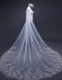 the back of a wedding veil with flowers on it, in front of a dark background