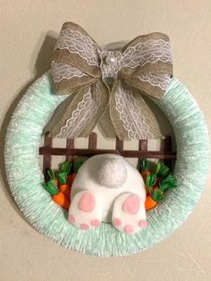 a paper plate wreath with an animal on it and a bow hanging from the front