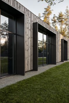 an exterior view of a building with wooden sidings and glass doors on the outside