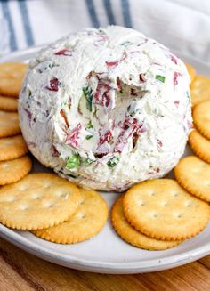 a plate with crackers and a cheese ball sitting on top of it next to some crackers