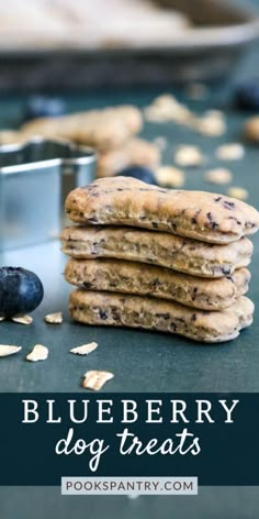 blueberry dog treats stacked on top of each other next to a cookie tin and fresh blueberries