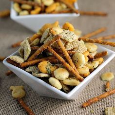 two white bowls filled with snacks on top of a table