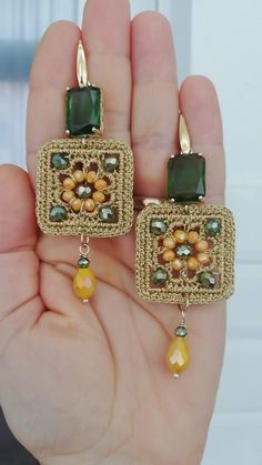 a pair of earrings with green and yellow beads