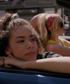 two women sitting in the back seat of a car, one with her head resting on her shoulder