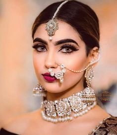 a woman with makeup and jewelry on her face