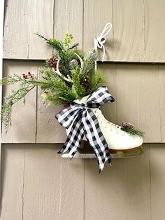 This listing is for 1 large white figure skate. Made from a real ice skate which I've adorned with pine and fir branches, red berries, a faux antler and holiday cheer that I've carefully nestled, then topped off with a black and white Buffalo check bow. The skate hangs from its laces.  The toe has a bit of evergreen with a pine cone to finish it off! This skate measures about 14" in length, 21" in height and 5" deep.  The skate is not brand new but looks great! This decorated ice skate will be a perfect accent to your front door, inside your home or hanging from your old sled.  Ice skates always stir up memories of days gone by out on the lake, skating with family and friends.   🔎Please note length of each skate. The sled pictured is used as a photo prop and not for sale. These skates mak Ice Skates Decorated For Christmas, Decorating With Ice Skates, Christmas Sleds Decorated, Lake Skating, Christmas Sled Decoration