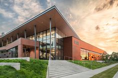 a large building with stairs leading up to it's entrance and grass on the ground