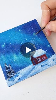 someone is painting a small house in the snow with a paintbrush and pencils