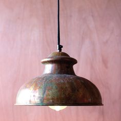 a metal light hanging from a wooden ceiling