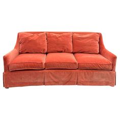 an orange couch with four pillows on it's back and one arm folded out