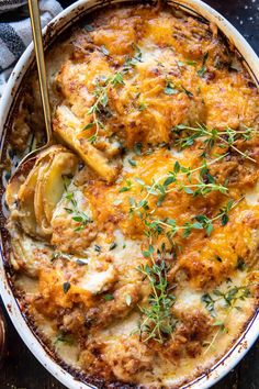 a casserole dish with chicken, cheese and herbs garnished on top