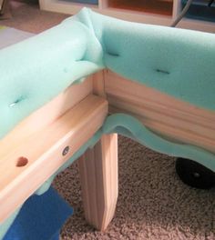 a close up of a bench made out of wood and foam with blue paint on it