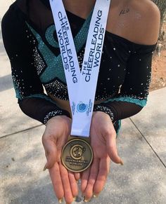 the woman is holding her gold medal in one hand and wearing a black top with sequins on it