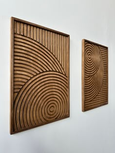 two wooden art pieces hanging on the wall