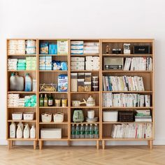 a book shelf filled with lots of books and other items next to a white wall