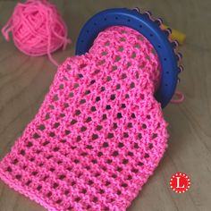 a pink crocheted cloth and ball of yarn