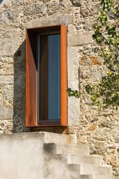 an open window on the side of a stone building