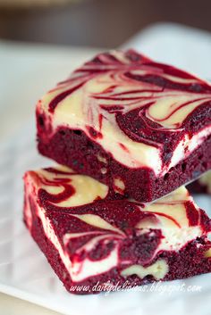 two red velvet brownies are stacked on top of each other with white frosting