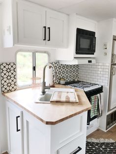 a kitchen area with sink, stove and microwave in it's center island next to an open door