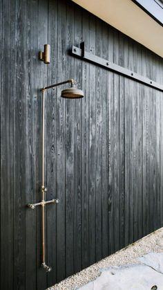 an outdoor shower in front of a wooden building