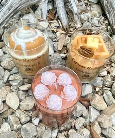 two cups filled with desserts sitting on top of rocks