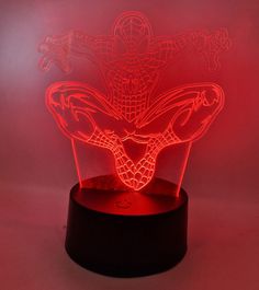 a red light that is on top of a black stand with an image of spider - man