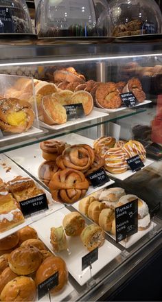 a display case filled with lots of different types of doughnuts and pastries