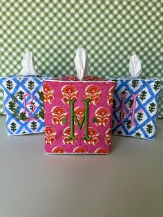 three tissue boxes with monogrammed designs on them