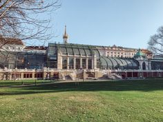 a large building with a glass roof in the middle of a park