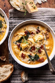 two bowls of soup with spinach, cheese and bread on the side next to each other