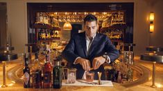 a man in a suit preparing drinks at a bar