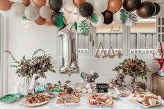 a table topped with lots of food and balloons