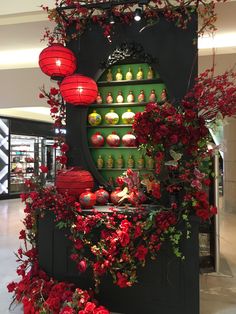 a display case with red flowers and lanterns