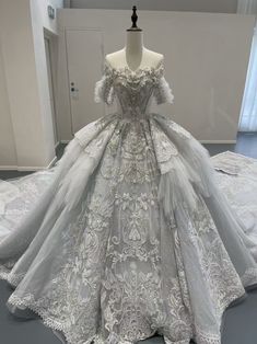 a white wedding dress on display in a room